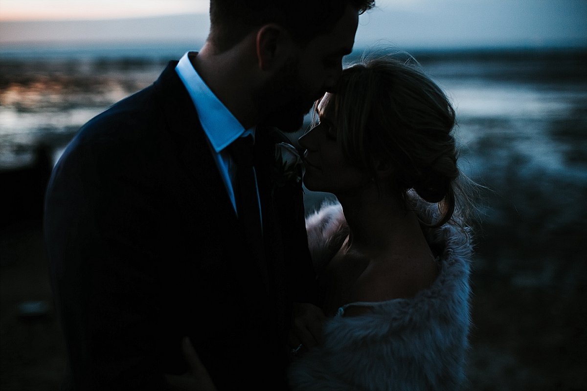 Bride and Groom hugging on Whitstable beach at sunset