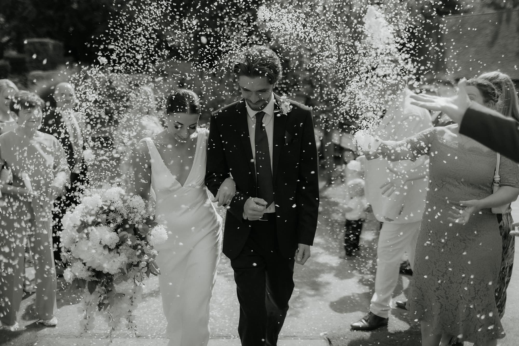 Bride and Groom walking through confetti tunnel