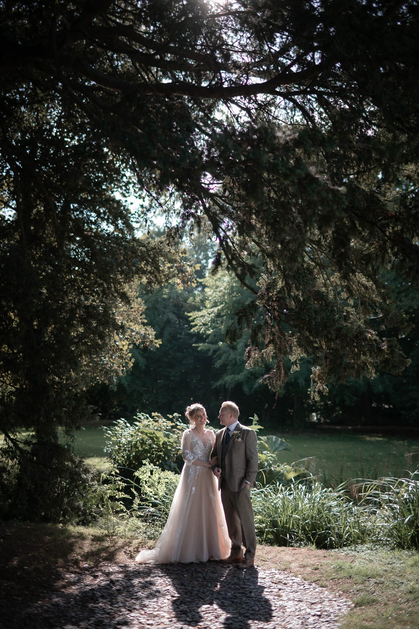 Bride and groom lit with warm light in a forest